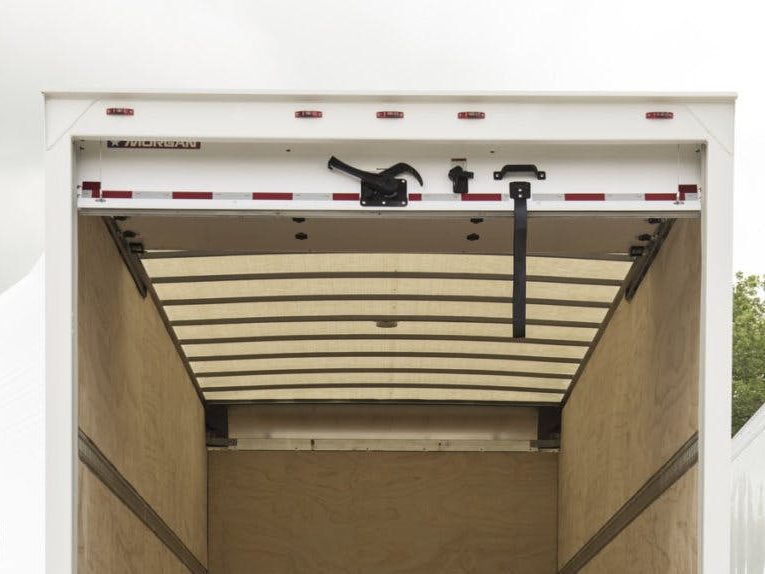 Box truck rolling door raised at the rear of a delivery truck