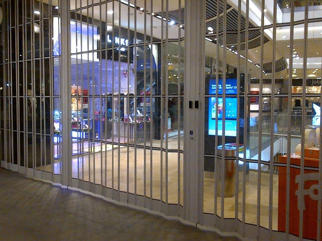 Folding security grille closing off a storefront after hours