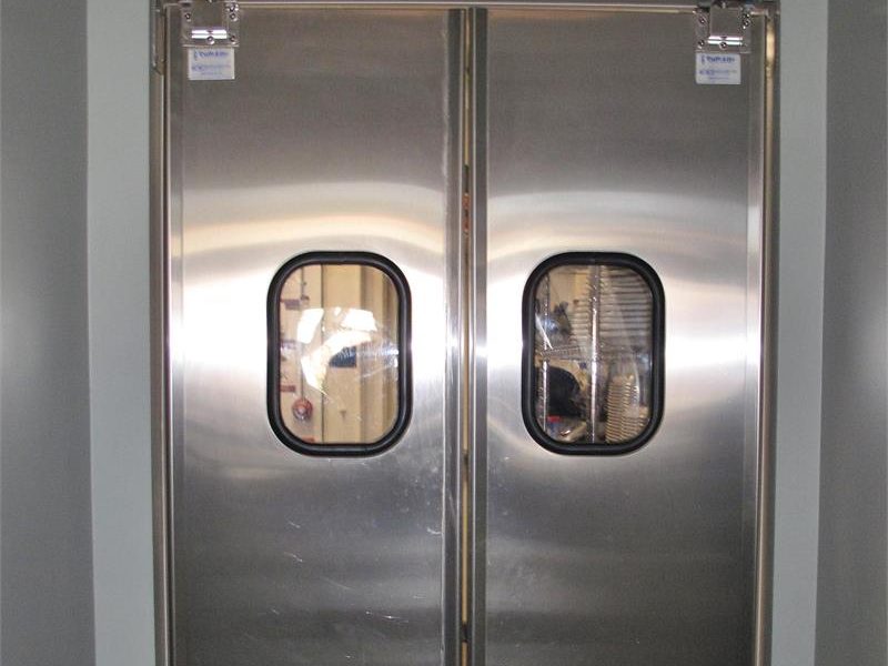 Stainless steel double impact traffic doors in a commercial kitchen