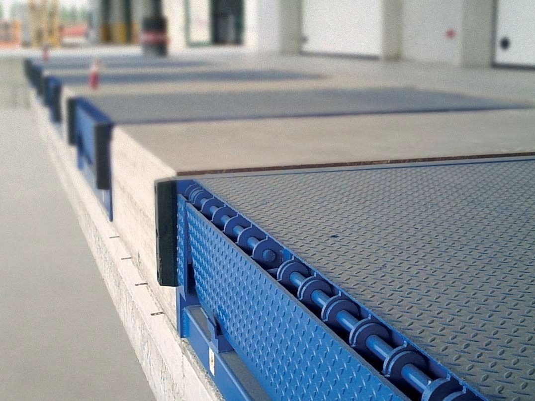 Loading dock levelers and dock bumpers along a warehouse dock