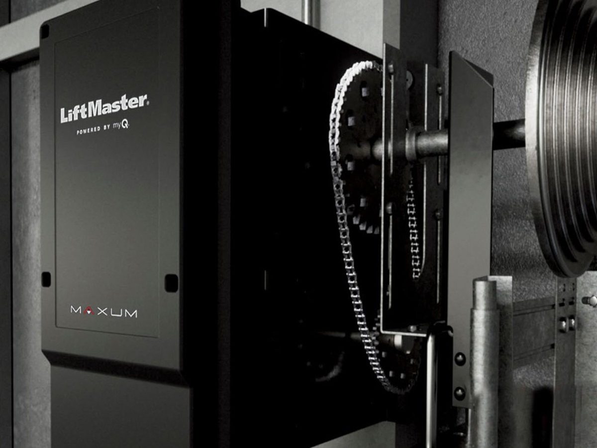 Chain-drive commercial door operator mounted beside a rolling door barrel